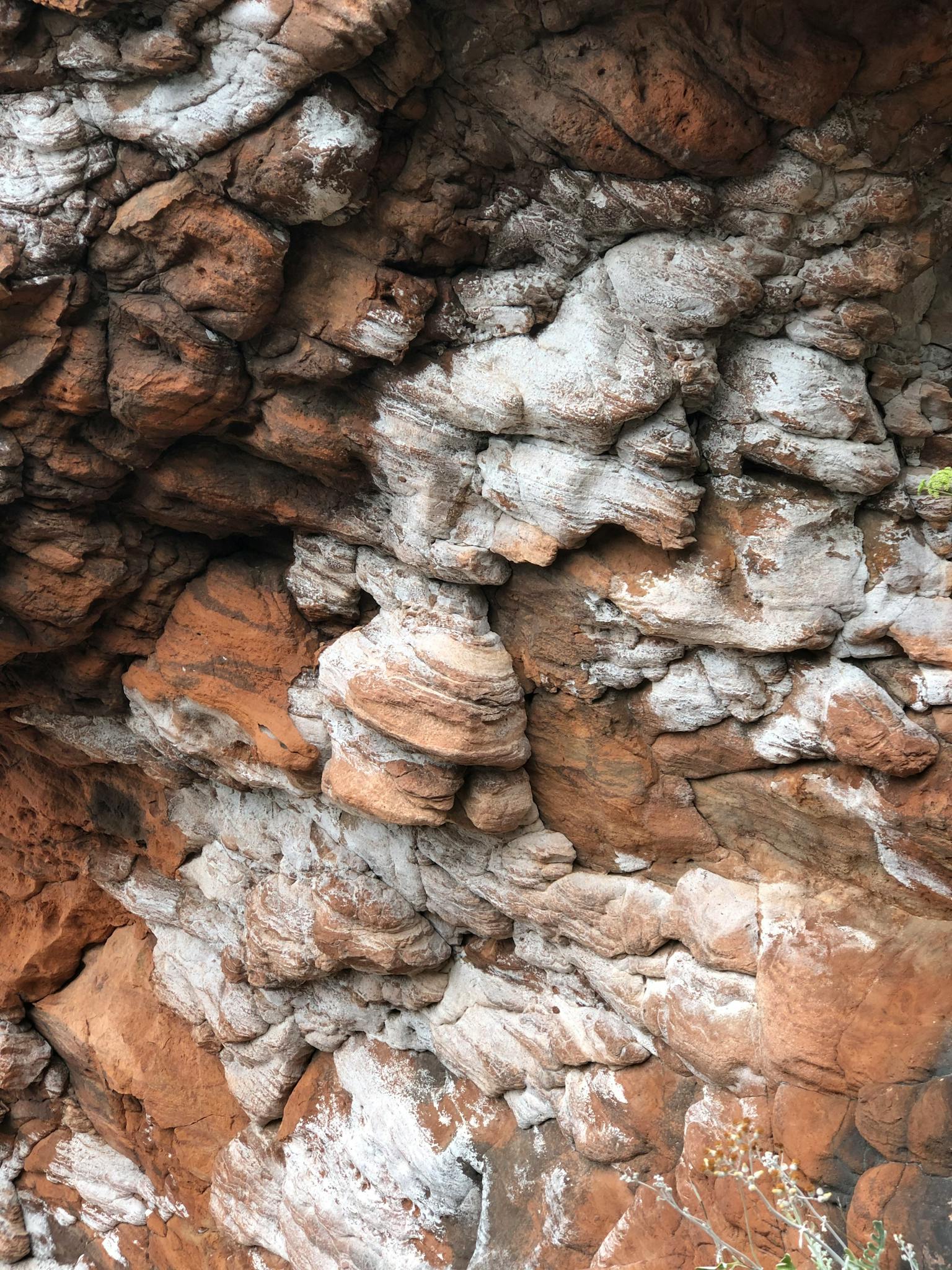 Close-up of uniquely layered red and white rock formation showcasing natural textures and patterns.